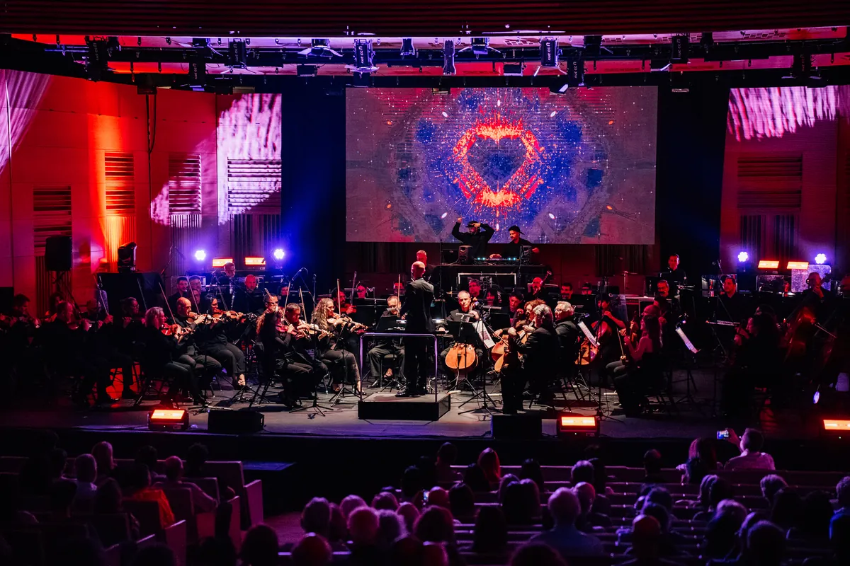 La orquesta bajo luces rojas y magentas